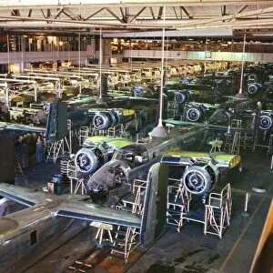 Assembly line production of B-25 bomber aircraft at the North American Aviation plant in Inglewood, California, during World War II. Photographed by Alfred T. Palmer, 1942
