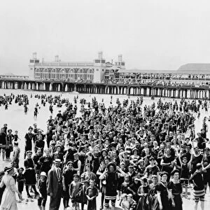 ATLANTIC CITY: BEACH. A large crowd of people on the beach, on the pier and standing
