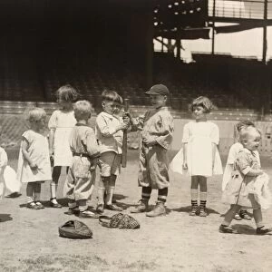 BASEBALL: BOYS AND GIRLS. Young boys and girls on a baseball field at a major league stadium. Photograph, early 20th century