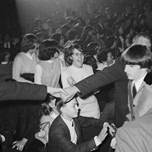 THE BEATLES, 1964. Security guards guiding Ringo Starr to the stage for the Beatles