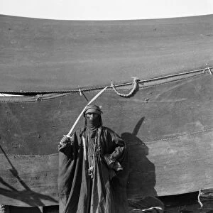 BEDOUIN MAN, c1910. A cloaked Bedouin man with a sword. Photograph, c1910