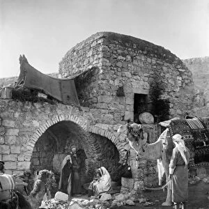 BETHLEHEM: HOME, c1928. A family with camels outside a stone home in Bethlehem