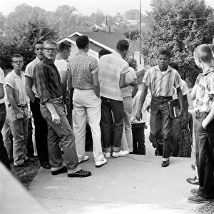 A black student walking through a crowd of white boys in Clinton, Tennessee, during a period of violence related to school integration, 4 December 1956. Photographed by Thomas J. O Halloran