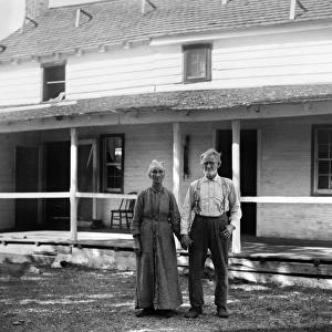 Captain Tate with his wife, standing in front of the Kitty Hawk Post Office, North Carolina. Photograph by Wright Brothers, 1900
