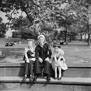 CENTRAL PARK, 1942. A sailor with girls in Central Park, New York City