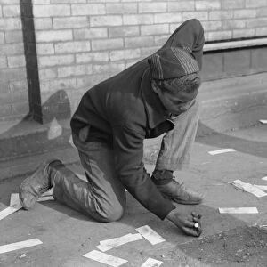 CHICAGO: MARBLES, 1941. An African American boy shooting marbles on a sidewalk in Chicago