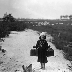 CHILD LABOR, 1910. A ten year old berry picker, Rose Biodo, carries two pecks at