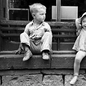 CHILDREN, 1940. Children of gold miners sitting on a store window sill, Mogollon, New Mexico