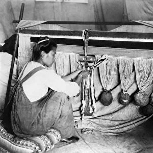 CHILKAT WEAVING, c1910. A Chilkat woman weaving a blanket in Alaska. Photograph by Winter & Pond