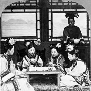 CHINA: PEKING, c1902. Four Manchurian women playing cards and having tea, Peking, China