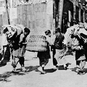 CHINA: RAG-PICKERS, c1920. Rag-pickers carrying bundles of rags down the street in China