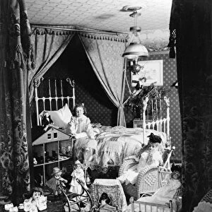 CHRISTMAS MORNING, c1902. A happy girl in her bedroom surrounded by toys on Christmas morning