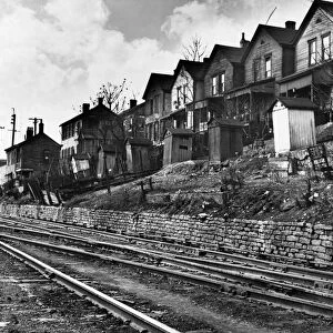 CINCINNATI: HOUSES, 1935. A row of low-income houses with outhouses facing railroad tracks, Cincinnati, Ohio. Photograph by Carl Mydans in December 1935