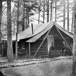 CIVIL WAR: LOG CABIN, 1864. Colonel John R. Coxe seated with a lady in front of his log cabin at the winter quarters at the Army of the Potomac headquarters at Brandy Station, Virginia. Photograph, February 1864
