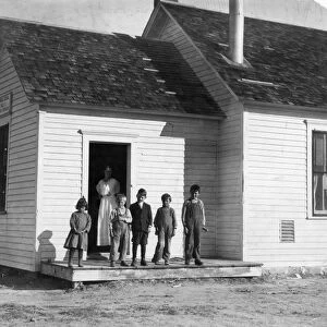 COLORADO SCHOOLHOUSE, 1915. Five pupils and their teacher outside a one room schoolhouse