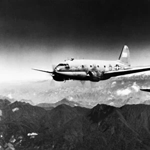 A Curtiss-Wright C-46 Commando transport aircraft flying over the Himalayas between India and China during World War II, c1944