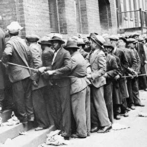DEPRESSION: HARLEM, 1931. Men lined up outside an unemployment office in Harlem, New York City, 1931