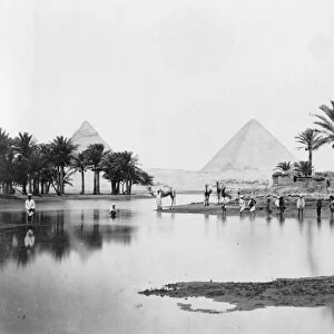 EGYPT: PYRAMIDS. A view of the pyramids with people wading in a lake in the foreground. Photograph, mid or late 19th century