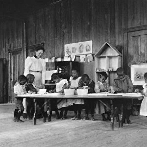 ELEMENTARY SCHOOL, c1900. Kindergarten students washing and ironing at Whittier Elementary School