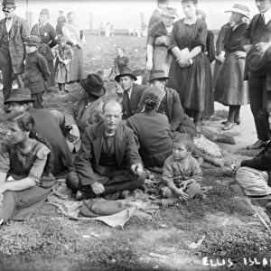 ELLIS ISLAND, C1910. New immigrants sitting on the lawn at Ellis Island. Photograph