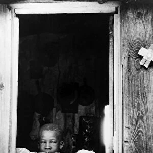 FARM CHILD, 1940. Son of a tobacco tenant farmer in the doorway of their home near Farmingham