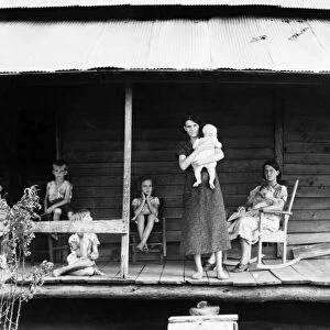 FARM FAMILY, 1937. A cotton sharecropper family on the front porch of a farmhouse in Macon County