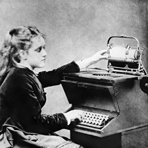 FIRST TYPIST, 1872. Lillian Sholes, the first typist, using a prototype typewriter
