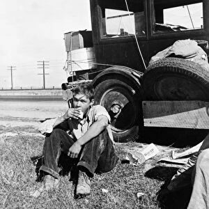 FLOOD REFUGEE, 1936. A son of a migrant worker eating roadside while traveling