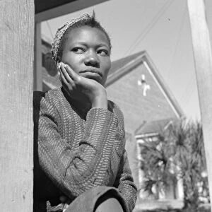 FLORIDA: WOMAN, 1943. A young woman sitting on her porch on Sunday morning in Daytona Beach