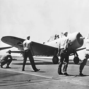 Fly 1 the take-off signal officer gives a fighter plane the Go sign on an U. S. Navy aircraft carrier, 1942