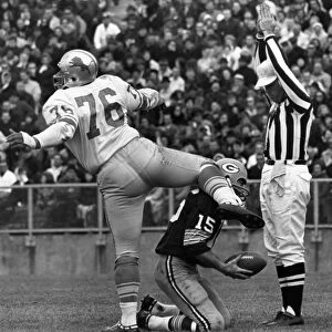 FOOTBALL GAME, 1965. Defensive tackle Roger Brown of the Detroit Lions exults after sacking quarterback Bart Starr of the Green Bay Packers (kneeling) in the end zone for a safety, during a game at Lambeau Field, Green Bay, Wisconsin, 7 November 1965