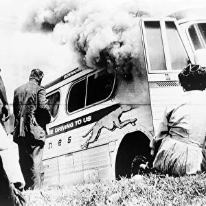FREEDOM RIDERS, 1961. A group of Freedom Rider civil rights activists watch as their bus burns