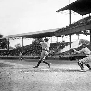 GEORGE H. RUTH (1895-1948). Known as Babe Ruth. American professional baseball player, swinging at a pitch, with Garret catching. Photograph, c1920