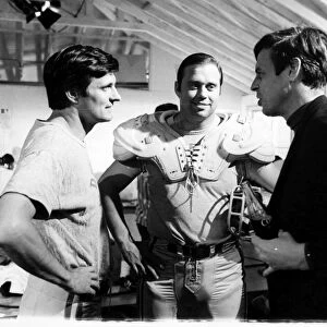 GEORGE PLIMPTON (1927-2003). American writer and editor. Plimpton (far right) with John Gordy (center), Detroit Lions guard, and Alan Alda during the filming of Paper Lion, based on Plimptons book. Photographed 12 March 1968