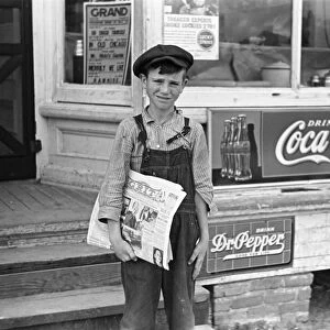 GEORGIA: NEWSBOY, 1938. A farmers son selling the newspaper Grit in a rural town, Irwinville, Georgia. Photograph by John Vachon in May 1938