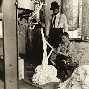 HINE: CHILD LABOR, 1908. Boy using a warping machine with a man overseeing his