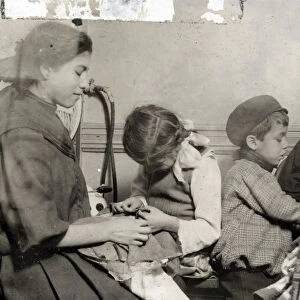 HINE: CHILD LABOR, 1910. Young garment workers sewing piecework in a tenement apartment