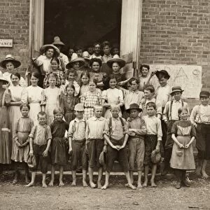 HINE: CHILD LABOR, 1911. A cotton mill supervisor with a group of young spinners