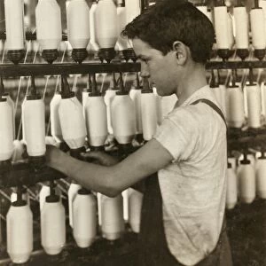 HINE: CHILD LABOR, 1916. A young boy spinning at the textile mill in Fall River, Massachusetts