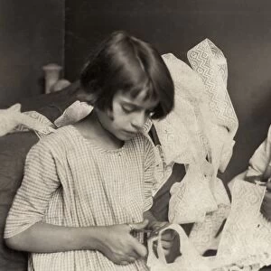 HINE: CHILD LABOR, 1924. A young girl and boy cutting lace at home in New York City