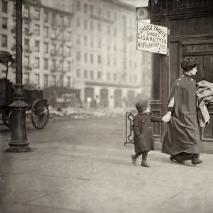 HINE: HOME INDUSTRY, 1912. A woman and son carrying clothing for home-work near