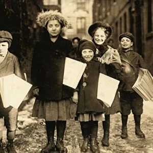 HINE: NEWSBOYS, 1909. Newsboys and newsgirls coming through the alley carrying