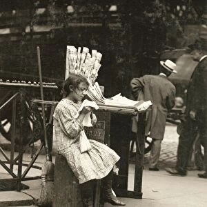 HINE: NEWSGIRL, 1910. A young newsgirl seated on a crate while tending to the newspaper