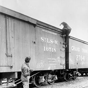 HOBOS, c1915. A hobo climbing on top of a railroad car. Photograph, c1915