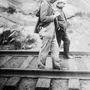 HOBOS, c1920. Hobos walking along the railroad tracks, after being kicked off the train