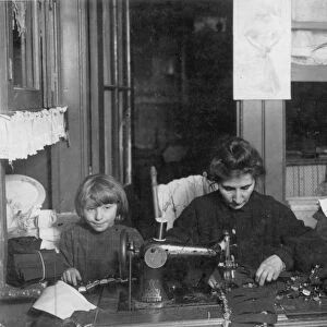 HOME INDUSTRY, 1910. A New York tenement family making garters. Photographed by Lewis Hine