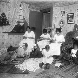 HOME INDUSTRY, c1910. Italian immigrant family doing garment piecework in their home