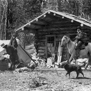 IDAHO: LOG CABIN, c1903. A man on horseback in front of a log cabin in Idaho. Photograph