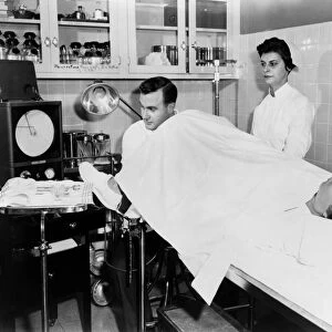INFERTILITY CLINIC, 1956. Dr. Marvin Hans performing a tubal insufflation test