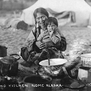 INUIT KITCHEN, 1916. An Inuit woman and her son at an outdoor kitchen near Nome, Alaska